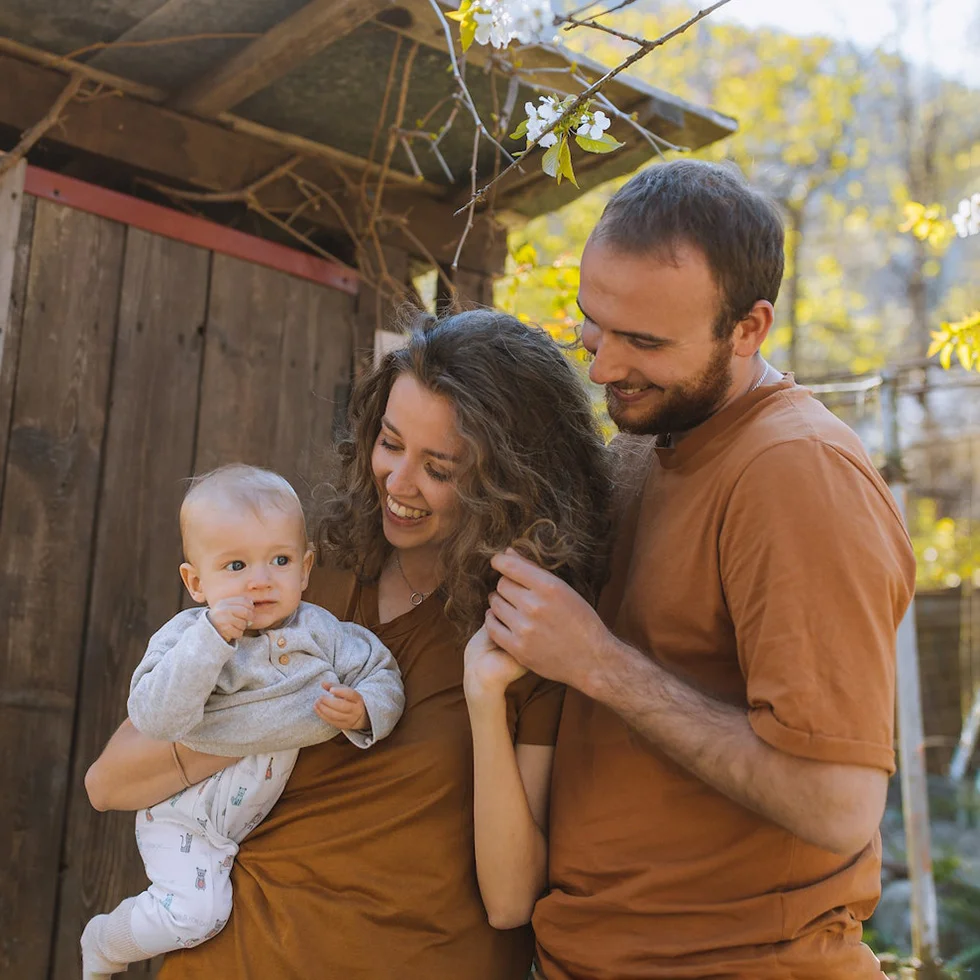 Mom and dad happy with baby outdoors
